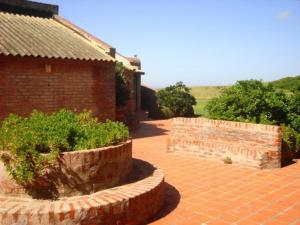 a brick building with a brick walkway next to a building with bushes at Complejo Casa Clara in Santa Clara del Mar +2 photos