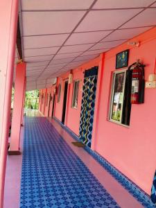 a corridor of a pink building with a blue floor at Blue Bird Residency in Neil Island
