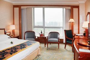 Habitación de hotel con cama, escritorio y sillas en Beijing Asia Pacific Garden Hotel, en Tongzhou