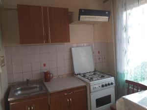 a small kitchen with a stove and a sink at Уютная квартира не далеко от центра города in Penza