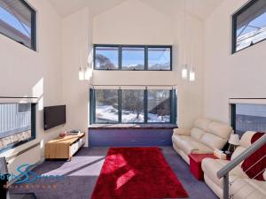 a living room with a couch and a red rug at Talgara 2 in Thredbo