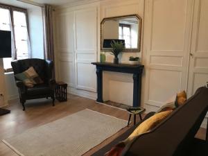 a living room with a fireplace and a mirror at Salardine Apartments - Cosy Suite in Châlus