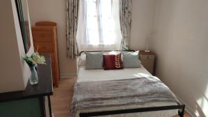 a small bedroom with a bed with a window at Salardine Apartments - Cosy Suite in Châlus