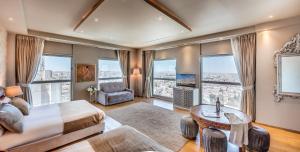 a bedroom with a bed and a table and windows at My Jerusalem View in Jerusalem