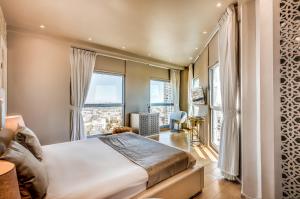 a bedroom with a bed and a large window at My Jerusalem View in Jerusalem