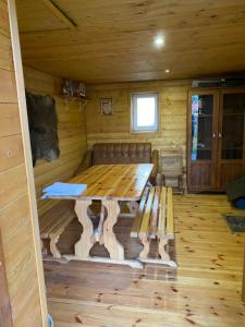 a wooden table and bench in a cabin at Usadba Tikhiy Ugolok in Nyasvizh