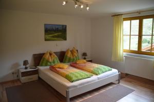 a bedroom with a bed with green and yellow pillows at Reiters-Ferienhaus in Russbach am Pass Gschütt