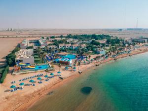 BM Beach Resort في رأس الخيمة: اطلالة جوية على شاطئ فيه ناس ومظلات