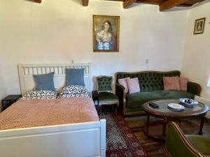 a bedroom with a bed and a couch and a table at Róza Vendégház in Buják