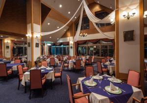 uma sala de jantar com mesas e cadeiras azuis em Aomori Winery Hotel em Ōwani