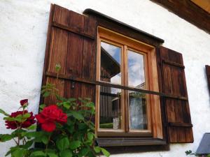 a window on the side of a house with red flowers at Ferienhaus Pucher in Grundlsee