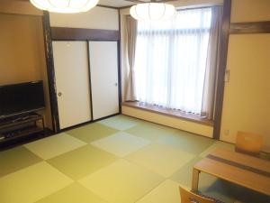 a living room with a large window and a tiled floor at Oyado Hachibei in Takayama