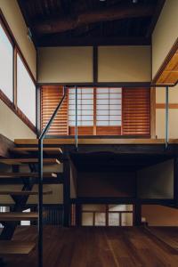 Habitación vacía con suelo y ventanas de madera. en Tsukihi House Kyoto, en Kioto