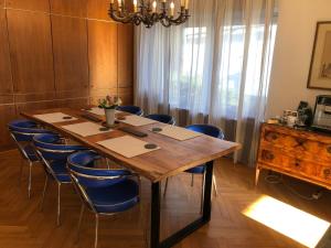 a dining room with a wooden table and blue chairs at Gästehaus Burkhardt in Düsseldorf