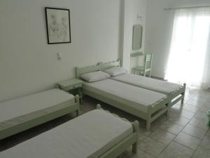 a room with three beds and a window at Four Seasons Rooms & Apartments in Ios Chora