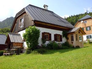 une maison avec un toit métallique sur un champ vert dans l'établissement Ferienhaus Pucher, à Grundlsee