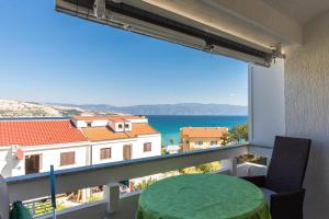 ein Balkon mit Tisch und Blick auf das Meer in der Unterkunft Marica A2 - Nr 1 in Baška