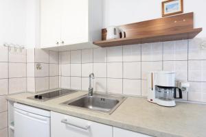 eine Küchentheke mit Spüle und Kaffeemaschine in der Unterkunft Marica A2 - Nr 1 in Baška