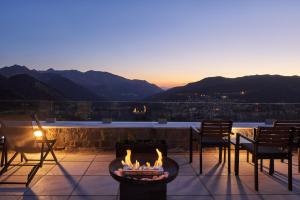 a fire pit on a patio with a view of the mountains at Grand Forest Metsovo - Leading Hotels of the World in Metsovo