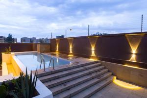a rooftop pool with stairs and lights on a building at Kozi Suites Nairobi Airport in Nairobi