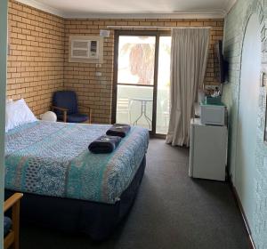 a bedroom with a bed and a balcony at Ocean View Villas in Geraldton