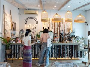 two women standing at a counter in a store at Silsopa Hostel in Nong Khai