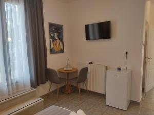a room with a table and a television on the wall at Xenonas ΚITHΑIRON in Vília