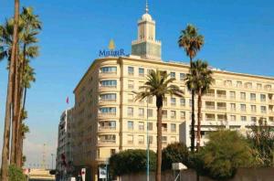 ein großes weißes Gebäude mit einem Turm darüber in der Unterkunft Grand appartement de luxe vue mer in Casablanca