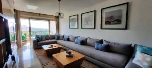 ein Wohnzimmer mit einem grauen Sofa und blauen Kissen in der Unterkunft Grand appartement de luxe vue mer in Casablanca