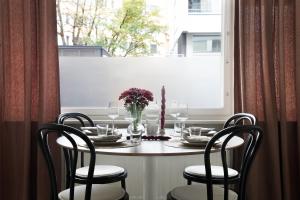 a table with chairs and a table and a window at Trendy Nordic Studio by Tram Stop in Helsinki