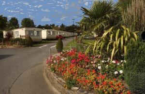 a street with a bunch of flowers in a garden at Devon Barnstaple Self Catering Tarka Holiday Park Free Wi-Fi Spacious Static Caravan sleeps 4 Pets allowed location Devon EX31 4AU Just 6 miles from Saunton Sands Please note no sign written vehicles are allowed to park on the holiday park overnight in Barnstaple