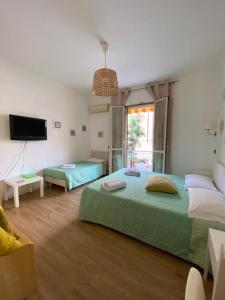 1 Schlafzimmer mit 2 Betten und einem Flachbild-TV in der Unterkunft Lumìa Bed and Breakfast in Syrakus
