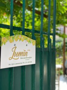 ein Schild auf einem grünen Zaun mit einem Schild drauf in der Unterkunft Lumìa Bed and Breakfast in Syrakus