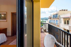 d'un balcon avec une chaise blanche et une vue. dans l'établissement Apartamentos Casa Maria, à Sant Antoni de Portmany