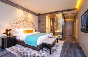 a bedroom with a king sized bed and a table at Cachet Boutique Kunming Artime in Kunming