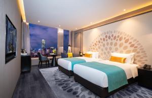 two beds in a hotel room with a view at Cachet Boutique Kunming Artime in Kunming