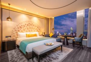 a hotel room with a bed and a view of a city at Cachet Boutique Kunming Artime in Kunming