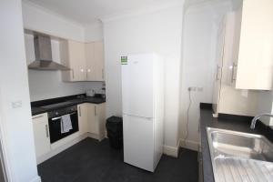a kitchen with a white refrigerator and a sink at Hillingdon Hill Court, Uxbridge in Hillingdon