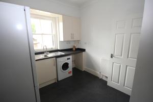 a kitchen with a sink and a washing machine at Hillingdon Hill Court, Uxbridge in Hillingdon