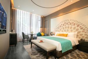 a hotel room with a bed and a table at Cachet Boutique Kunming Artime in Kunming