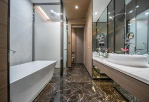 a bathroom with two sinks and a large mirror at Cachet Boutique Kunming Artime in Kunming
