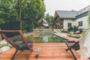 a backyard with a pool and two chairs and a house at Łubinowe Wzgórze Dom II in Nałęczów +125 photos