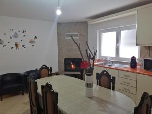 a kitchen and dining room with a table and a fireplace at Casa do Adro - Serra da Estrela in Cortes do Meio