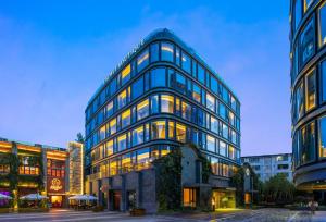 a tall glass building with many windows at Cachet Boutique Kunming Artime in Kunming