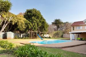 a swimming pool with a playground in a yard at Casas Navio Guest House in Johannesburg