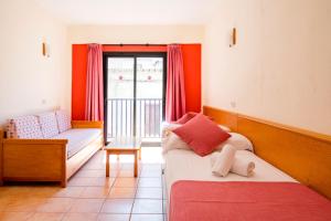 a room with a bed and a couch and a window at Apartamentos Casa Maria in San Antonio +52 photos