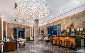 a lobby with a large chandelier hanging from the ceiling at Cachet Boutique Kunming Artime in Kunming