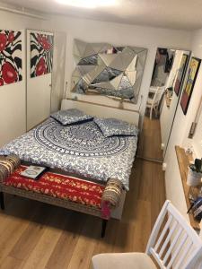 małą sypialnię z łóżkiem i lustrem w obiekcie Chez Sven - Studio 'Le Petit' w mieście Lohn-Ammannsegg