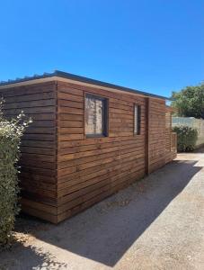 un pequeño edificio de madera con una ventana en él en Bungalow Chalet 35 m2 camping l ile d or Saint-raphael, en Saint-Raphaël