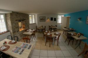 a restaurant with tables and chairs in a room at Hotel Du Cheval Blanc in Saint-Pol-de-Léon